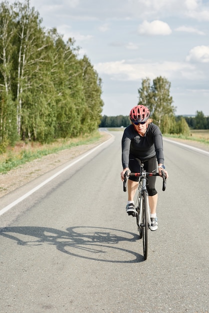 Athlète féminine en casque sur une balade à vélo dans une nature magnifique