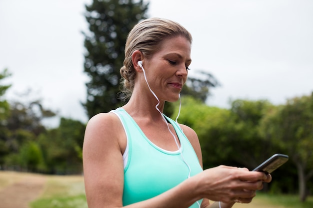 Athlète féminine écoutant de la musique sur téléphone mobile