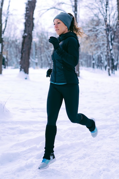 Photo athlète féminine exerçant dans le parc le jour d'hiver dans le parc