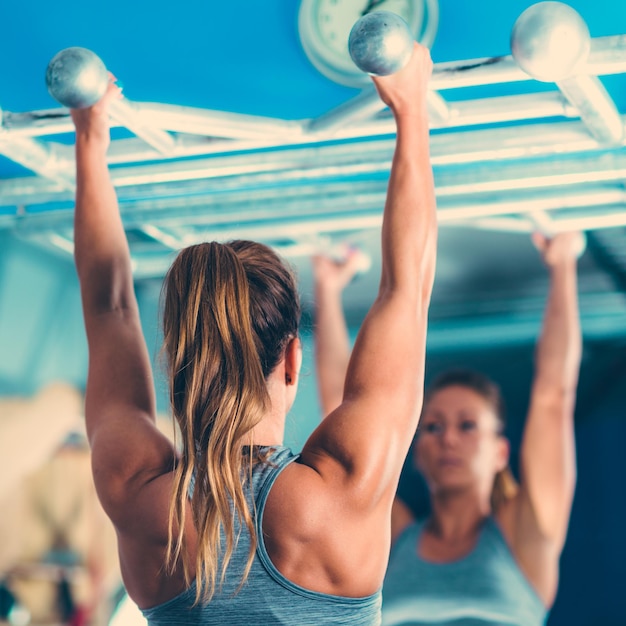 Athlète féminine faisant des tractions dans la salle de gym