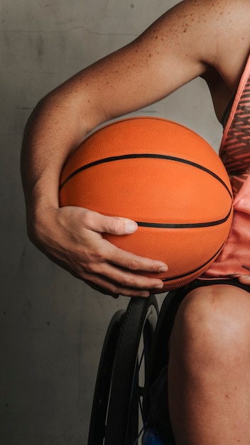 Athlète féminine en fauteuil roulant tenant un ballon de basket