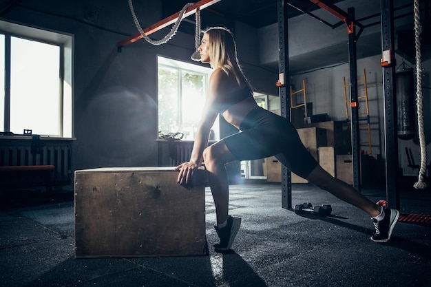 L'athlète féminine s'entraînant dur dans la salle de gym. Concept de remise en forme et de vie saine.