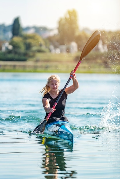 Athlète féminine s'entraînant en kayak sur le lac