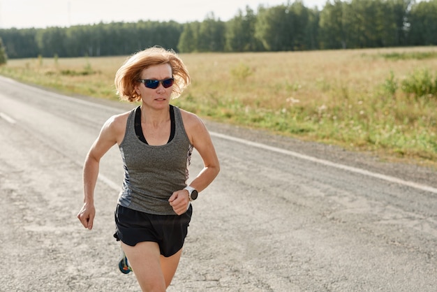 Athlète féminine s'exécutant sur une route, elle se prépare pour sa compétition