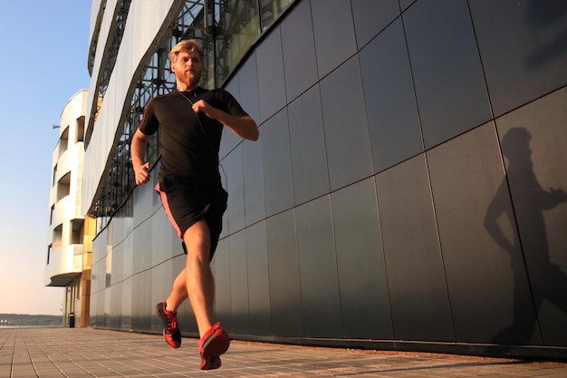 Athlète en forme. Bel homme adulte courant à l'extérieur pour rester en bonne santé, au coucher ou au lever du soleil. Coureur