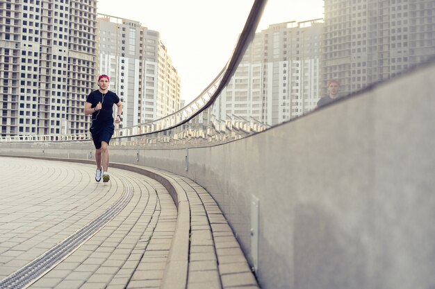 Athlète en forme qui court à l'extérieur pour rester en bonne santé. Jeune homme sportif en cours d'exécution