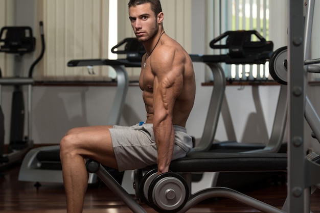Athlète en forme travaillant sur les boucles de concentration d'haltères biceps