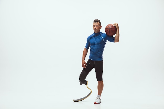 Athlète handicapé ou amputé sur fond de studio blanc, basket-ball