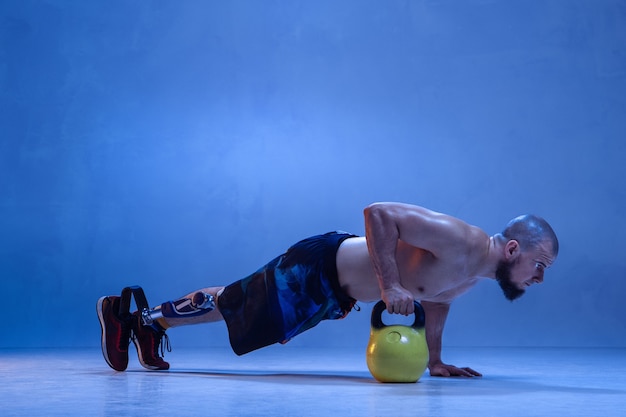 Athlète Handicapé Ou Amputé Isolé Sur Le Mur Bleu Du Studio