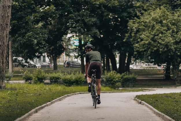 Athlète masculin caucasien dans des vêtements de sport faisant du vélo sur l'air frais