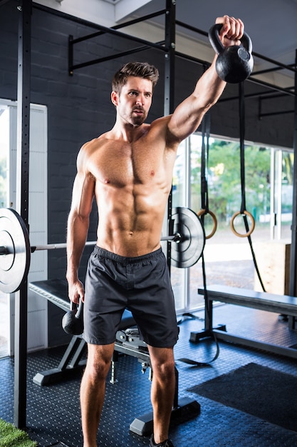 Athlète masculin exerçant avec des kettlebells