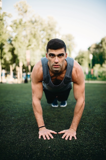 Athlète masculin faisant des exercices de push-up en plein air