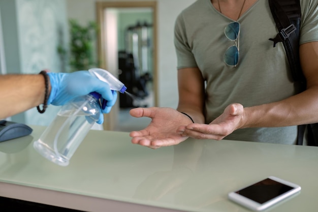 Athlète méconnaissable se désinfectant les mains à la réception du gymnase