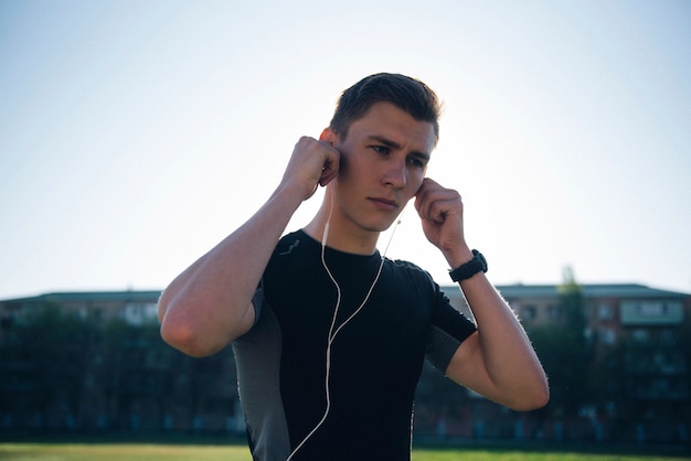 L'athlète met ses écouteurs avant de faire du jogging