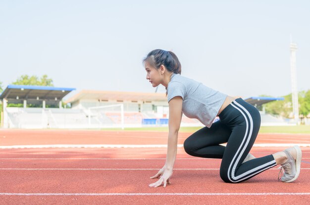 Athlète mignon asiatique sur une piste de course est prêt à courir,