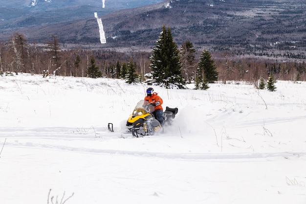 Athlète sur une motoneige se déplaçant dans la forêt d'hiver