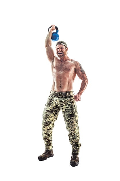 Athlète musclé bodybuilder homme en pantalon de camouflage avec un torse nu faisant fitness Kettlebells swing exercice sur blanc