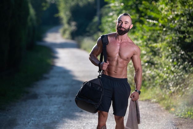 Athlète portant un sac de sport à l'extérieur dans le parc