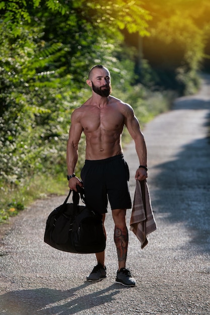 Athlète portant un sac de sport à l'extérieur dans le parc