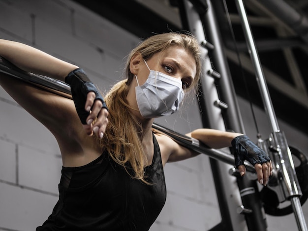 Athlète s'entraînant au gymnase pendant la pandémie portant un masque protecteur