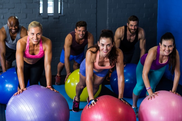 Athlètes souriant tout en exerçant sur ballon de fitness