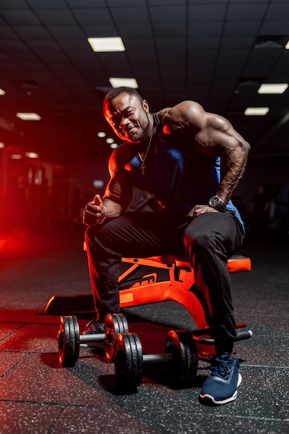 Athlétique bel homme musclé travaillant dans la salle de gym. Entraîneur de fitness fort.