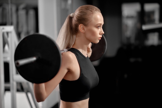 Athlétique, belle fille en vêtements de sport dans la salle de gym.