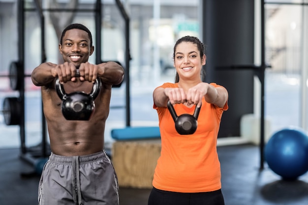 Athlétique homme et femme travaillant au gymnase de crossfit