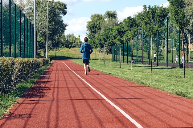 Photo athlétique jeune homme en cours d'exécution exercice d'étirement dans la matinée de bien-être et de sport de soins personnels