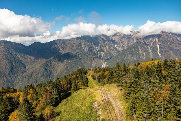 Photo l'atmosphère de la principale attraction touristique shin hotaka dans les couleurs d'automne avec un téléphérique et un téléphérique au service des touristes japon alpes shinhotaka ropeway et feuillage d'automne