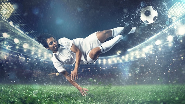 L'attaquant de football frappe le ballon avec un coup de pied acrobatique en l'air au stade