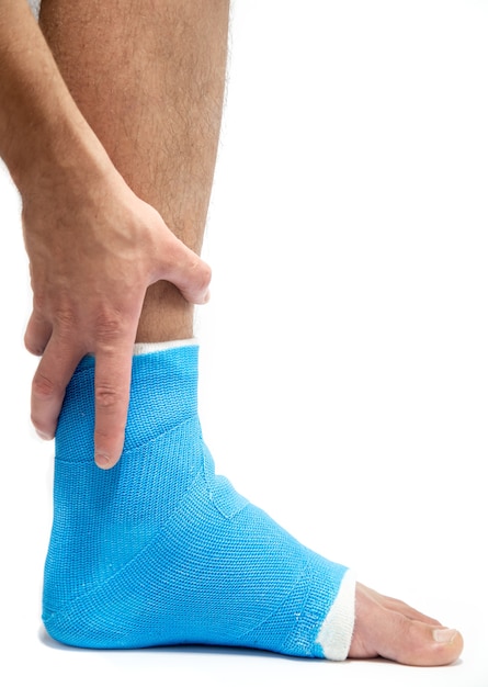 Attelle de cheville bleue. Jambe bandée moulée sur un patient de sexe masculin. Concept de blessure sportive.