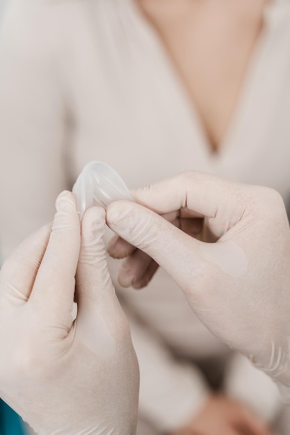 Des attelles nasales sont installées dans le nez pendant la septoplastie pour corriger la déformation de la cloison nasale Le médecin ORL tient des attelles nasales dans les voies respiratoires deux morceaux de plastique maintenus à l'intérieur du nez