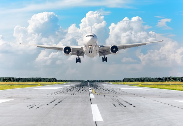 Atterrissage d'un avion de passagers dans le ciel nuageux sur une piste