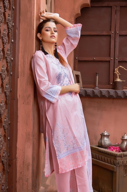 Attitude de fille mince mignonne posant vêtue d'une robe Desi pour une séance photo traditionnelle