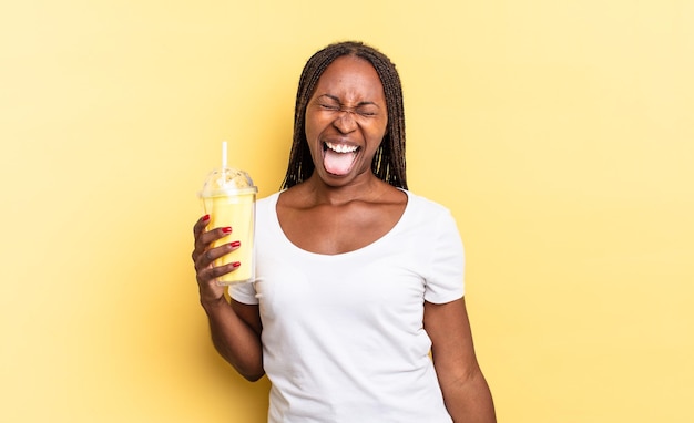 Avec une attitude joyeuse, insouciante et rebelle, plaisantant et tirant la langue, s'amusant. concept de milk-shake