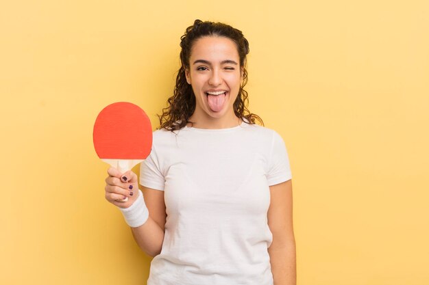 Avec une attitude joyeuse et rebelle, plaisantant et tirant la langue