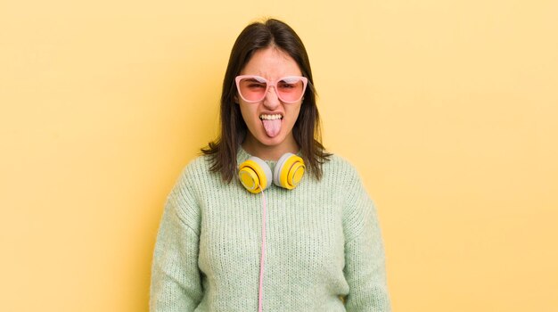 Avec une attitude joyeuse et rebelle, plaisantant et tirant la langue