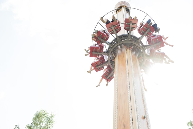 Une attraction dans le parc, les gens montent sur un carrousel, une vue d'en bas par une journée ensoleillée