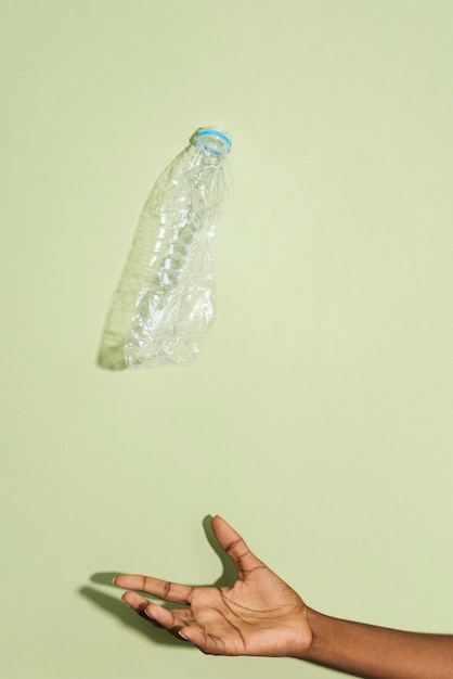 Photo attraper une bouteille en plastique écrasée à la main