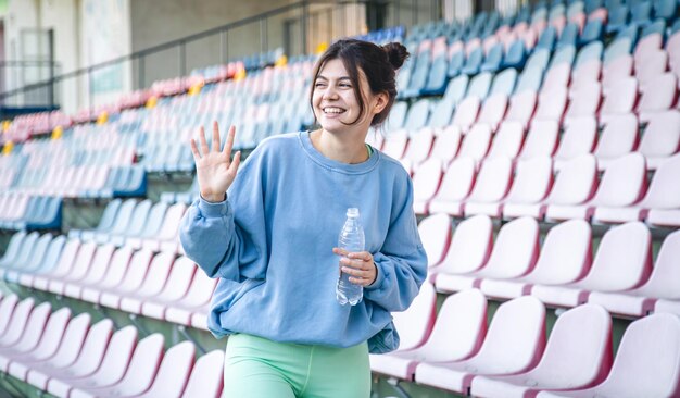 Attrayante jeune athlète féminine boit de l'eau après une séance d'entraînement