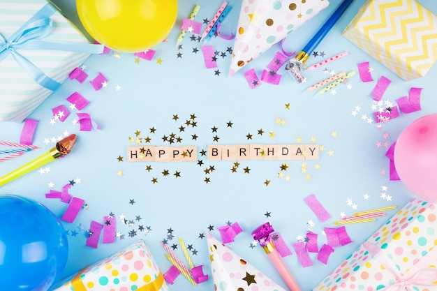 Photo attributs de fête d'anniversaire boules colorées confetti cadeaux bougies pour gâteau phrase joyeux anniversaire