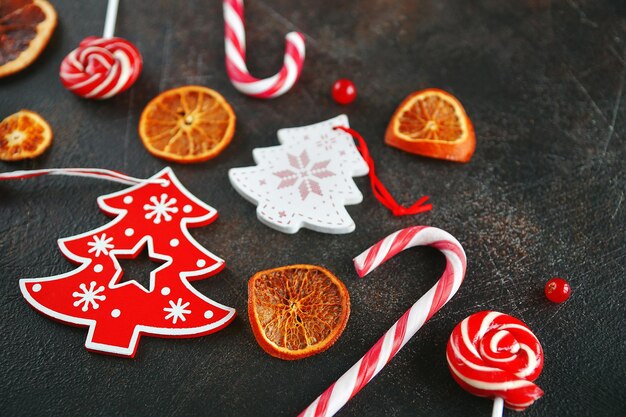 Attributs de Noël. Oranges caramélisées, branches de sapin et canne à sucre sur fond sombre, mise au point sélective