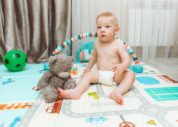 Au-dessus de l'angle de l'adorable petit garçon allongé sur des tapis de sol adaptés aux enfants jusqu'à la recherche