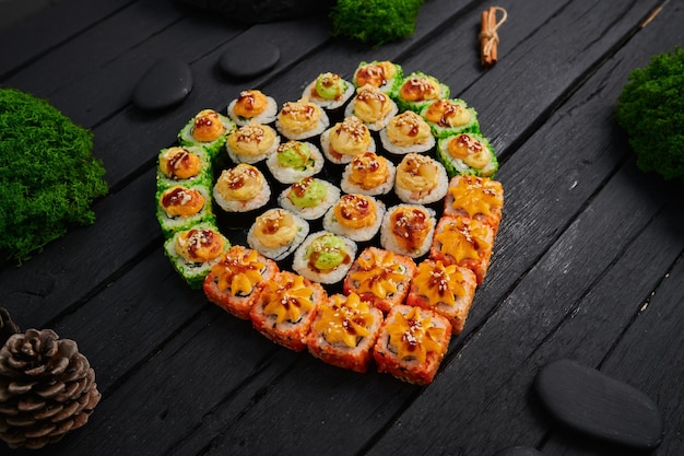 Au-dessus de la vue de divers sushis et rouleaux placés sur une planche de pierre Japanese food fest vue de dessus à plat