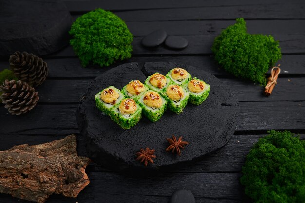 Au-dessus de la vue de divers sushis et rouleaux placés sur une planche de pierre Japanese food fest vue de dessus à plat