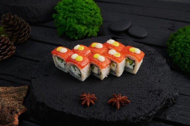Au-dessus de la vue de divers sushis et rouleaux placés sur une planche de pierre Japanese food fest vue de dessus à plat