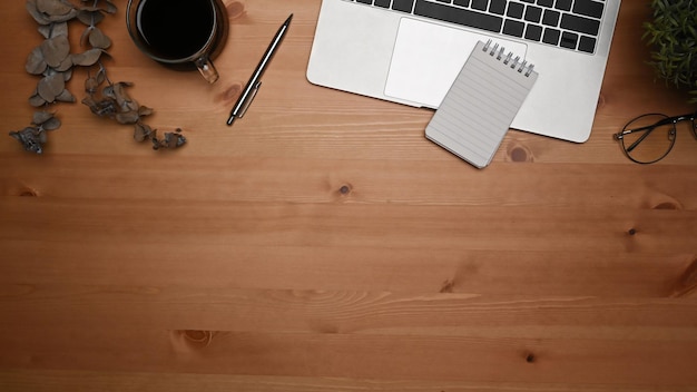 Photo au-dessus de la vue, espace de travail simple avec ordinateur portable et tasse à café sur un bureau en bois