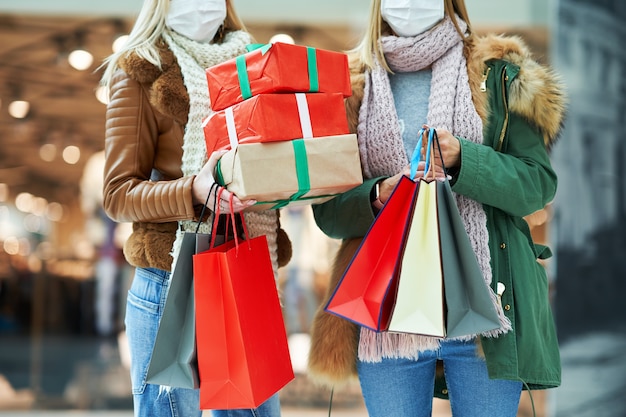 Au milieu de deux amis faisant du shopping ensemble portant un masque, concept de coronavirus