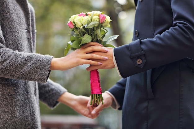 Au milieu du jeune couple avec des fleurs